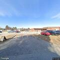 Person digging in dumpster behind business