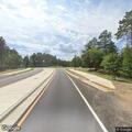Vehicle slides into ditch and knocks down road sign