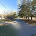 Person on skateboard pulled by dog in roadway