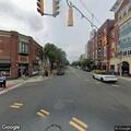 Person lying on sidewalk with blanket at East Main and Ocean