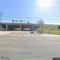 Man swinging machete at fence near freeway