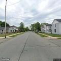 Person hunched over wheel in parked vehicle at intersection