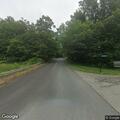 Elderly woman wearing robe walks on road with EKG leads