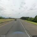 Pedestrian sitting on shoulder of interstate