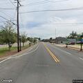 Tree limb brings power line down in roadway