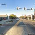 Older man in yellow jacket stumbles near street