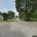 Person walking through yards near church in Knox City