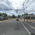 Broken road sign hanging over White Horse Pike