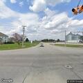 Vehicles parked in oncoming lanes near grain bins