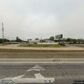 Person wearing red shirt found lying in grass near highway ramp