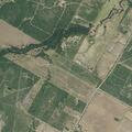 Grass fire spreading behind rural property