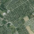 Officer checks Cadillac Escalade behind homes