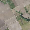 Grass fire spreads near creek and wooden bridge