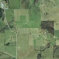 Hay baler and hay bales on fire in field near Yellville