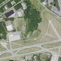 Man rolling in grass near highway department entrance