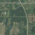 Field and grass fire spreading to pine trees