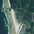 Children in water pushing logs into surf at Ecola Creek