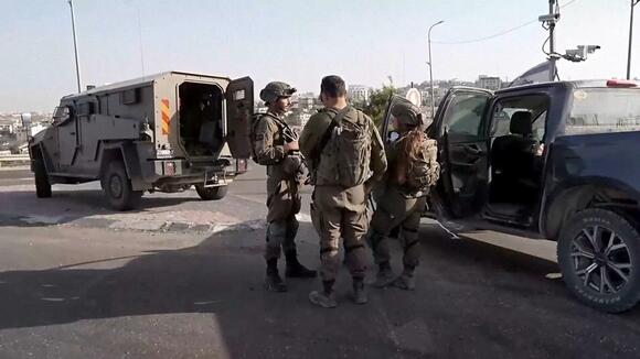 Two Palestinian gunmen opened fire on an Israeli checkpoint Friday