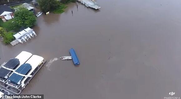 As a 12-metre shipping container floated out of control on the flooded ...