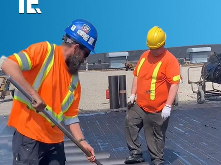📸This construction worker uses a mop to paint hot tar to prepare a
