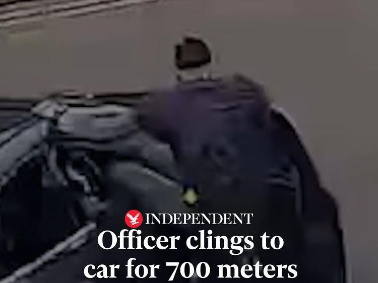 A police officer clung to a car for more than 700 metres as a man drove