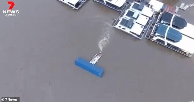 As a 12-metre shipping container floated out of control on the flooded ...