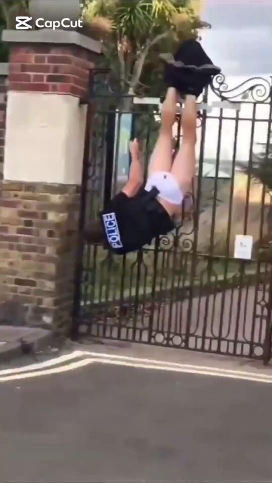 Police officer gets stuck hanging upside down from a fence during foot ...