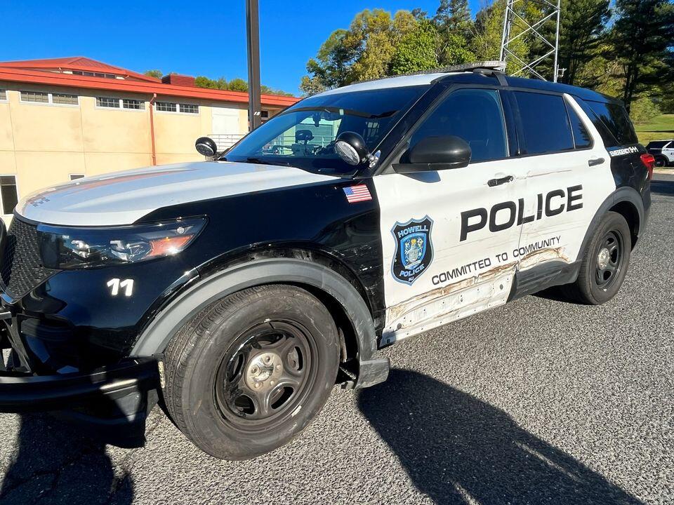 Howell police officers avoid injury after cruisers struck by passing